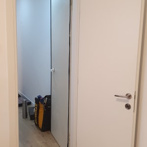 דלת לבנה פתוחה עם ידית מתכת כסופה