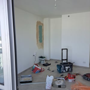 חדר עם קיר גבס, כלים וחומרי בנייה על הרצפה