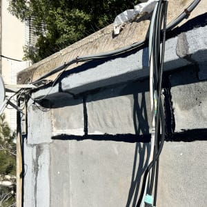 איטום גג עם זפת שחורה וכבלים חשמליים