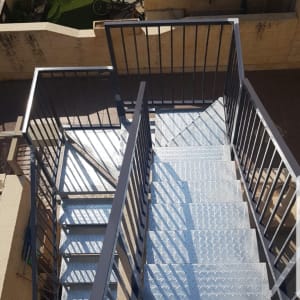 מדרגות מתכת עם מעקה ברזל בחוץ