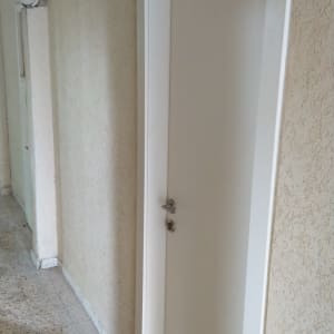 דלת לבנה עם ידית מתכת במסדרון