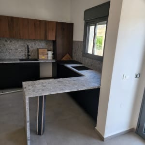 מטבח עם משטחי עבודה נקיים וארונות עץ