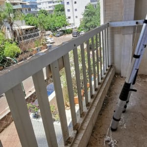 רשת נגד יונים מותקנת על מרפסת עם מעקה