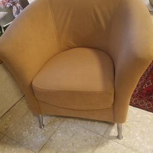 כורסה מרופדת בצבע חום בהיר עם רגלי מתכת