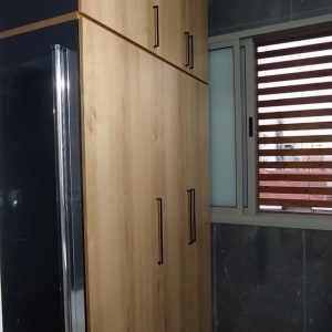 ארון עץ עם ידיות מתכת בחדר אמבטיה