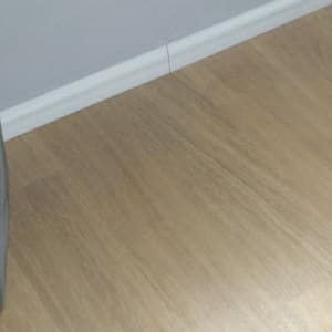 רצפת פרקט עץ בהירה ליד קיר לבן