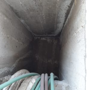 צינורות ירוקים ואפורים בתוך תעלת בטון