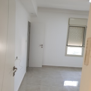 חדר צבוע בלבן בדירה ריקה מריהוט לאחר עבודת צביעה