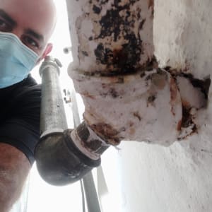 צינור חלוד עם חיבורים, אדם עם מסכה