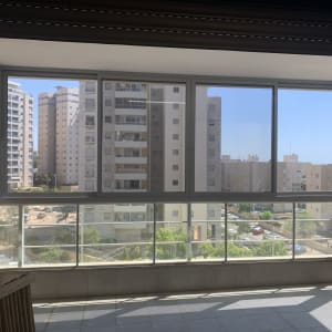 חלונות אלומיניום במרפסת עם נוף לעיר