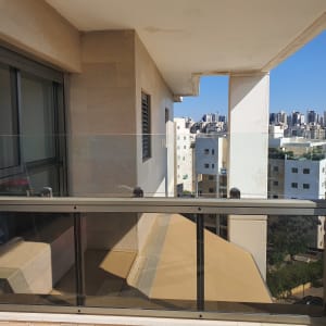 מעקה זכוכית במרפסת עם נוף עירוני