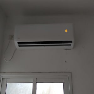 מזגן מותקן על קיר עם תצוגת טמפרטורה דולקת