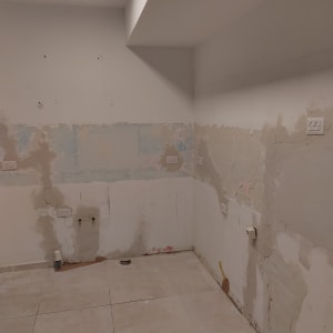 קיר עם חיבורים לצנרת, שקעי חשמל ואריחים