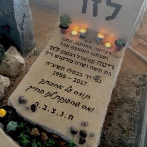 מצבה עם נרות, צמחים ואבנים קטנות