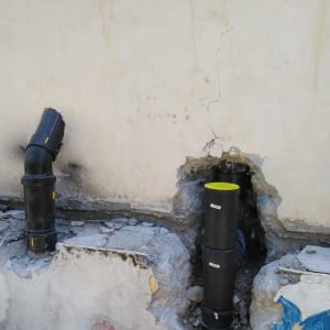 צינורות שחורים מותקנים בקיר עם חור