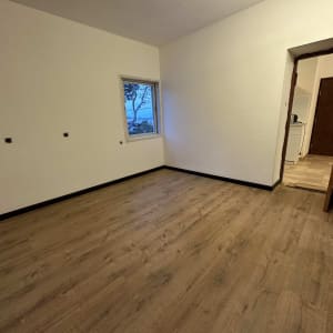 רצפת פרקט עץ בחדר ריק עם קירות לבנים