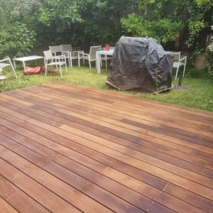 דק עץ בגינה עם צמחייה מסביב