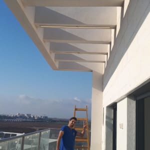 חשמלאי עם סולם וכלי עבודה במרפסת
