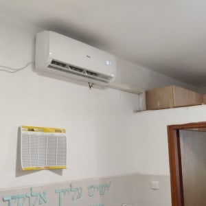 מזגן מותקן על קיר לבן בחדר