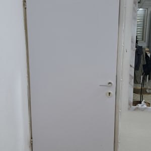 דלת לבנה עם ידית כסופה ומסגרת בהירה