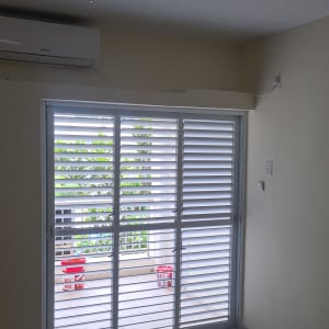 תריסי אלומיניום לבנים על חלון זכוכית