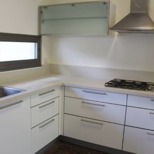 מטבח מודרני עם ארונות לבנים וכיריים