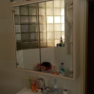 אריחי זכוכית ליד מראה בחדר אמבטיה