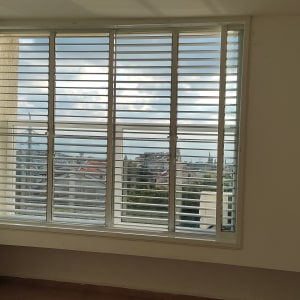 תריסי אלומיניום בחלון גדול עם נוף חיצוני