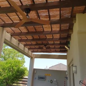 מאוורר תקרה מותקן על פרגולה מעץ