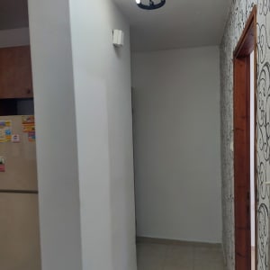 קיר צבוע בלבן עם דלת עץ ודוגמת טפט