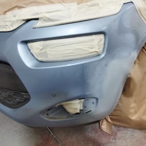 רכב בתהליך צביעה עם מסכות נייר על הפנסים