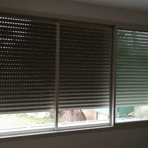 תריסי אלומיניום סגורים על חלון זכוכית