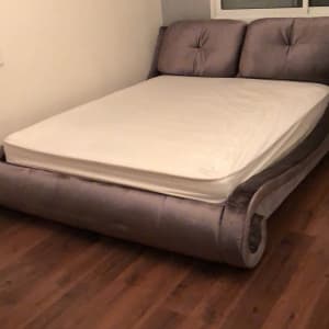 מיטה מרופדת עם מזרן לבן בחדר שינה