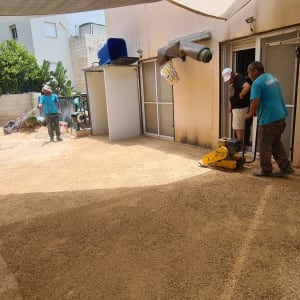 עובדים מכינים קרקע עם כלים לגינון בחצר