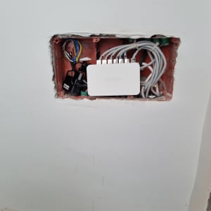 מתג רשת D-Link מותקן בקיר עם כבלים מחוברים