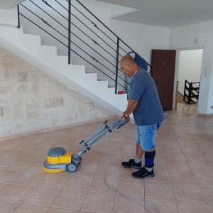 אדם מנקה רצפה עם מכונת פוליש חשמלית