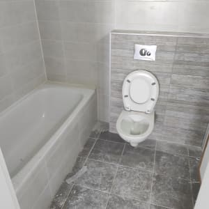 חדר אמבטיה עם לכלוך על הרצפה והאמבטיה