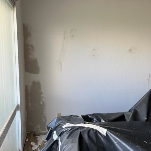 קיר עם תיקוני טיח ויריעות פלסטיק על הרצפה