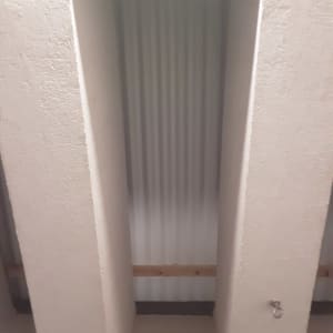 קיר בטון עם קרש עץ וטבעת מתכת