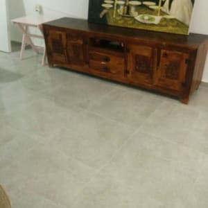 רצפת אריחים חדשה בחדר עם שידה מעץ