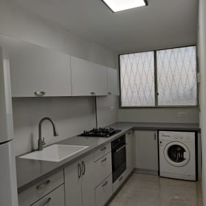 מטבח מודרני עם כיור, כיריים ותנור בילט-אין