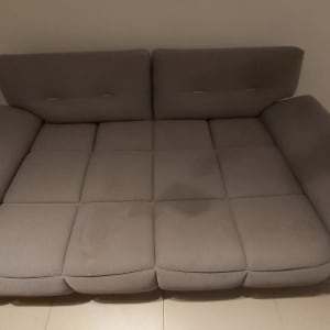 ספה אפורה עם כתמים נראים על המושב