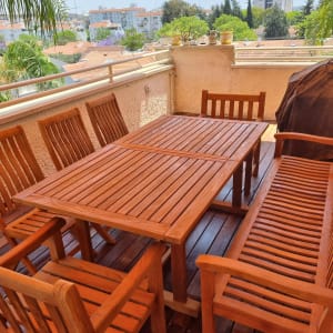 ריהוט גן מעץ על מרפסת עם שמשיה כתומה