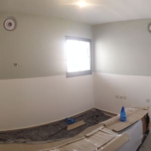 חדר צבוע בשני גוונים עם ציוד צביעה על הרצפה