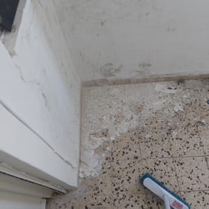 קיר מתקלף עם צבע מתקלף על הרצפה