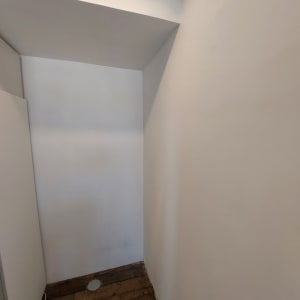 קיר גבס צבוע בלבן עם תקרה משופעת