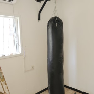 שק אגרוף תלוי על מתקן קיר עם סולם ליד