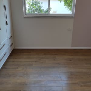 חדר עם רצפת עץ נקייה וחלון גדול