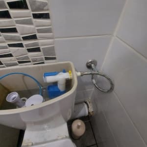 מיכל הדחה פתוח עם כלי עבודה וצינור מים