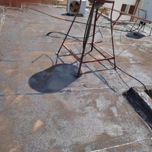 גג אטום עם חומר איטום כהה ומיכל מים